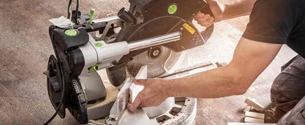 A professional wearing a black shirt using a Festool saw for cutting wood precisely at Triboro Paint near North Attleborough, MA